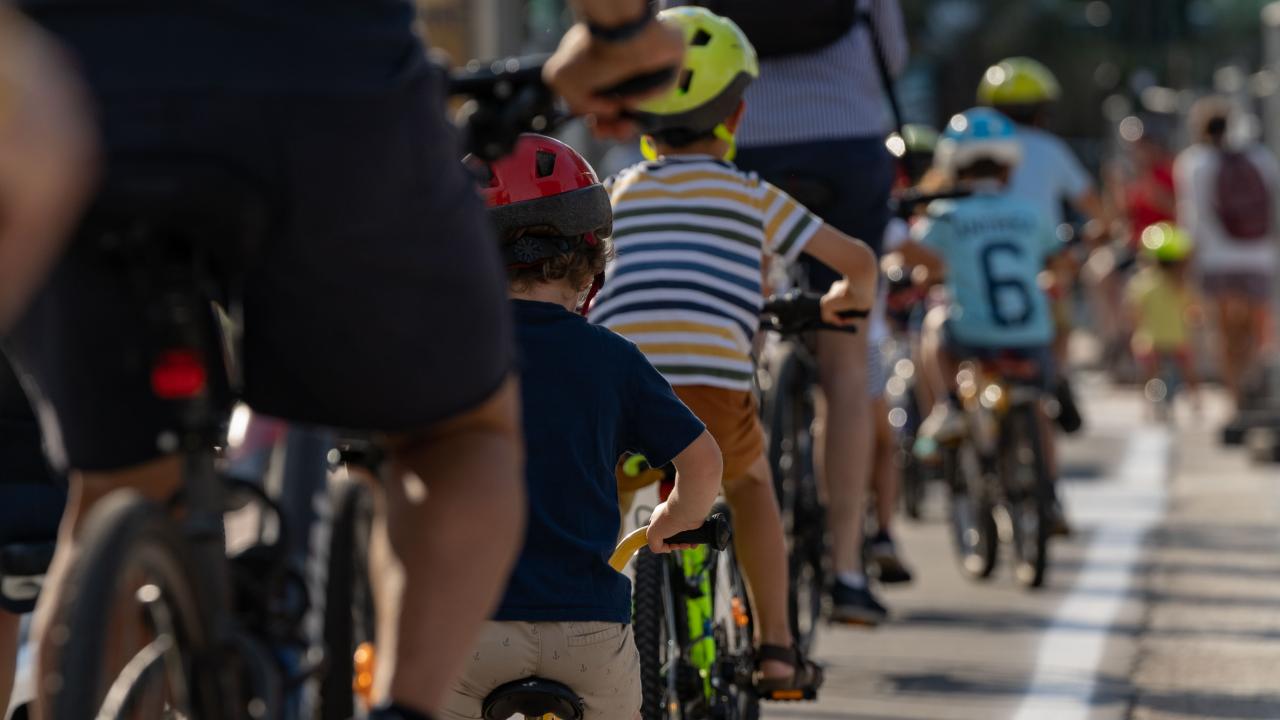 Un gruppo di persone in bicicletta su una strada.